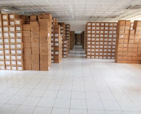 Gacaca court papers in boxes stacked one on top of another in a strongroom.